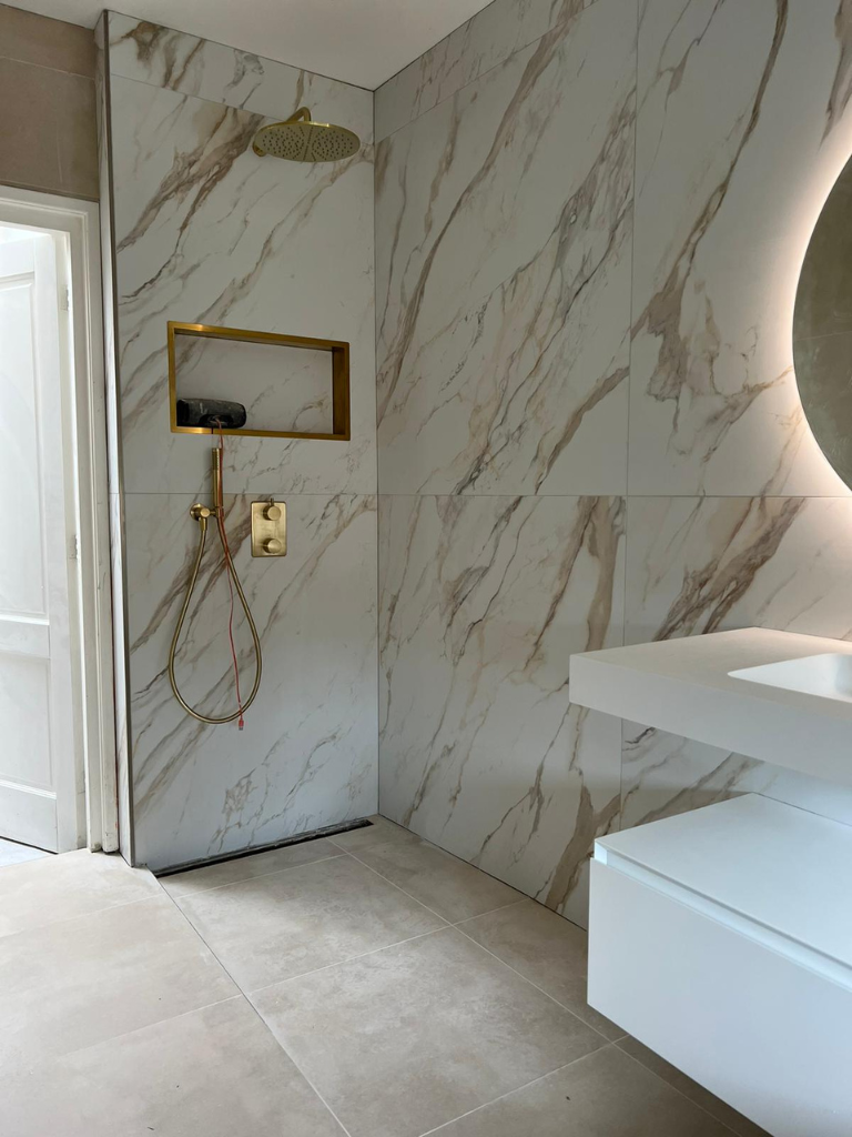 Luxe badkamer met marmerlook tegels en gouden accenten